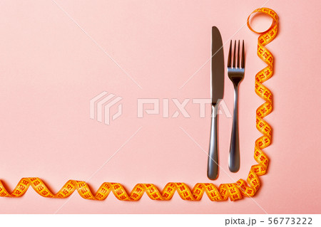 Top view of fork and knife and curled measuring Top view of fork and knife and curled measuring 56773222