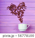 Grain of coffee in the form of a heart over a cup. 56778100