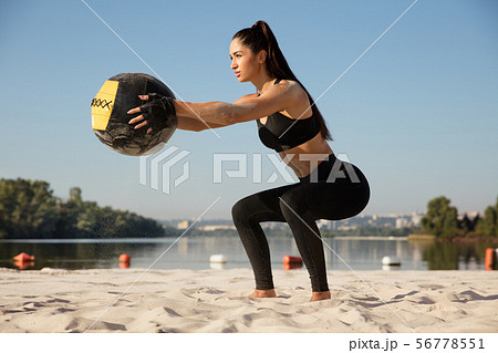Young healthy female athlete doing workout at the beach Young healthy female athlete doing workout at the beach 56778551