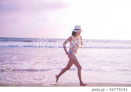 young woman on sunset beach and joyful running . young woman on sunset beach and joyful running . 56779281