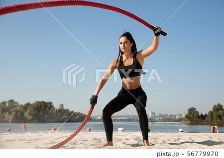 Young healthy female athlete doing workout at the beach Young healthy female athlete doing workout at the beach 56779970