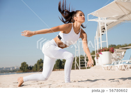 Young healthy female athlete doing workout at the beach 56780602