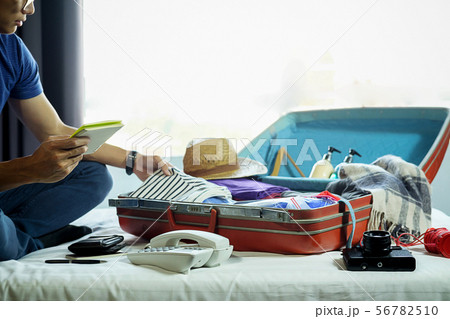 People packed suitcase with travel accessories on People packed suitcase with travel accessories on 56782510