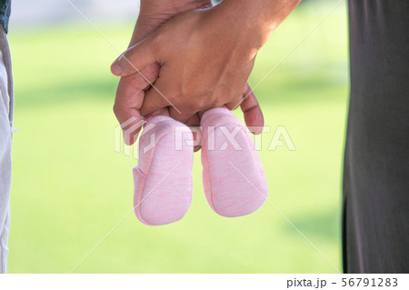 Farther and mother holding Small shoes Farther and mother holding Small shoes 56791283