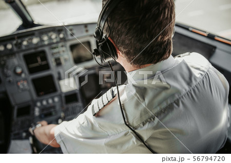 Caucasian adult man in uniform piloting modern airplane 56794720