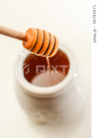 Honey dripping isolated on a white background, bee products by organic natural ingredients Honey dripping isolated on a white background, bee products by organic natural ingredients 56795671