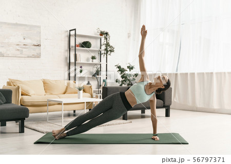 Merry woman balancing in side plank stock photo 56797371