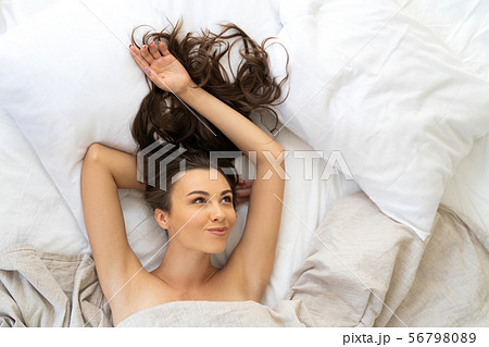 Beautiful young woman lying in her bed and smiling Beautiful young woman lying in her bed and smiling 56798089