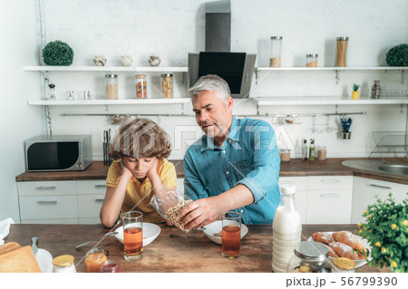 Mature father making breakfast for son at kitchen 56799390