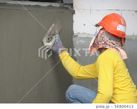 Brick wall plastered by construction workers 56800413