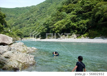 清流で遊ぶ子供（タコメガネで魚を探す）２ 56802932