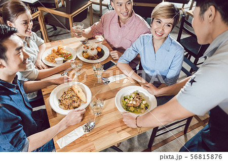 Male waiter serving food on table Male waiter serving food on table 56815876
