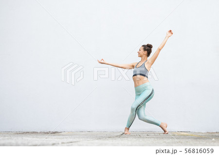 Fit sporty active girl in fashion sportswear doing yoga fitness exercise in front of gray wall Fit sporty active girl in fashion sportswear doing yoga fitness exercise in front of gray wall 56816059