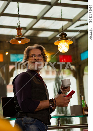 Cafe visitor smiling to a waiter passing by. 56817644