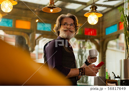 Cheerful man drinking coffee waiting for a friend. Cheerful man drinking coffee waiting for a friend. 56817649