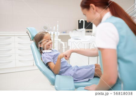 Smiling girl greeting her pleasant dental therapist Smiling girl greeting her pleasant dental therapist 56818038