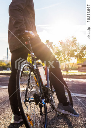 The cyclist is standing near road bike The cyclist is standing near road bike 56818647