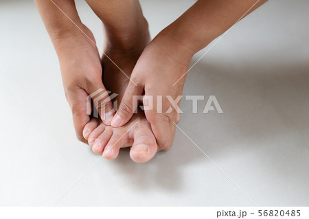Woman massaging her painful foot and finger 56820485
