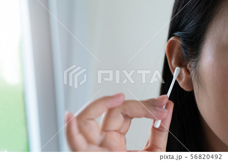 woman cleaning ear with cotton swab. Healthcare 56820492