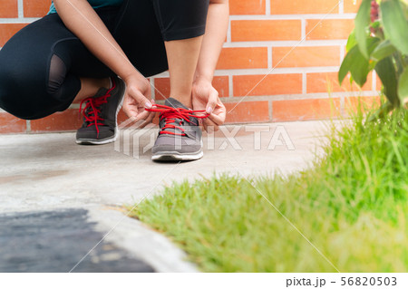 sport woman tying shoelace before running, outdoor 56820503