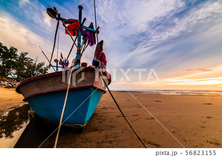 Beautiful sunrise over an old wooden fishing boat  56823155