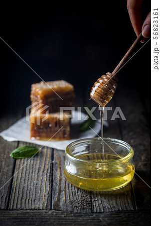 Honey dripping in glass jar Honey dripping in glass jar 56823161