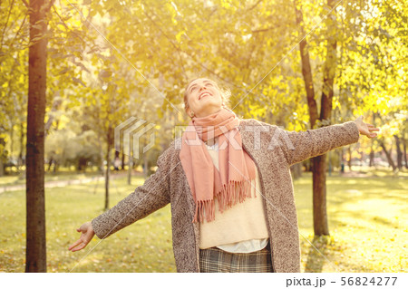 Beautiful autumn woman holding yellow maple leaf Beautiful autumn woman holding yellow maple leaf 56824277