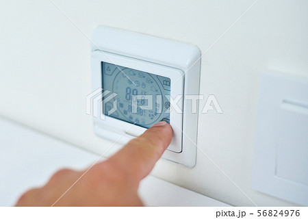 hand setting temperature on control panel 56824976