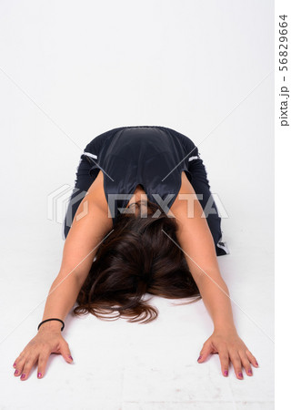 Full body shot of young Asian woman doing Child yoga pose Full body shot of young Asian woman doing Child yoga pose 56829664