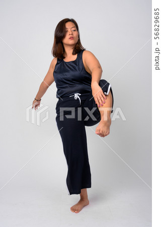 Young beautiful Asian woman dancing and standing on one leg Young beautiful Asian woman dancing and standing on one leg 56829685
