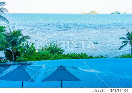 Umbrella and chair around beautiful luxury outdoor swimming pool with sea ocean view in hotel resort for holiday vacation travel Umbrella and chair around beautiful luxury outdoor swimming pool with sea ocean view in hotel resort for holiday vacation travel 56831191