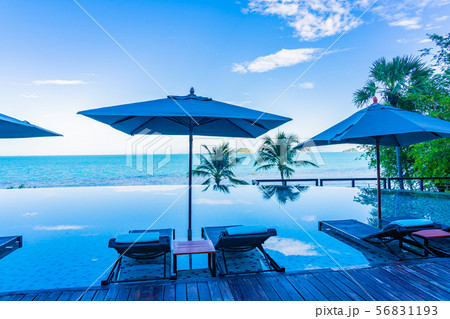 Umbrella and chair around beautiful luxury outdoor swimming pool with sea ocean view in hotel resort for holiday vacation travel Umbrella and chair around beautiful luxury outdoor swimming pool with sea ocean view in hotel resort for holiday vacation travel 56831193