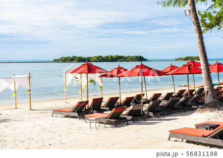 Beautiful outdoor tropical beach sea ocean with umbrella chair and lounge deck around there on white cloud blue sky 56831198