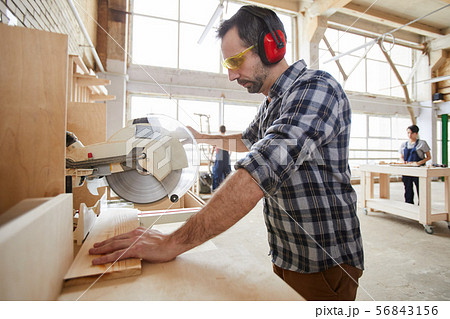 Carpenter Cutting Wood Side View Carpenter Cutting Wood Side View 56843156
