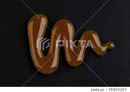 Caramel sauce isolated on black background, top view Caramel sauce isolated on black background, top view 56843267