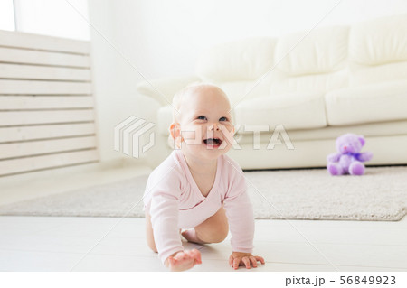 beautiful smiling baby crawling for the first time. beautiful smiling baby crawling for the first time. 56849923