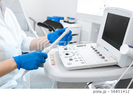 gynecologist puts a condom on the ultrasound gynecologist puts a condom on the ultrasound 56851412