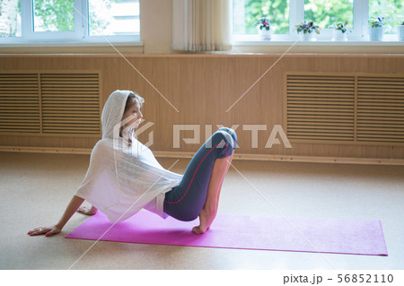 Young woman ballerina stands on her tip toes on the yoga mat - dance studio 56852110