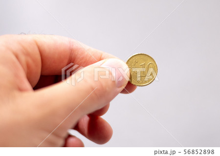 Hand holding a ten cent euro coin 56852898