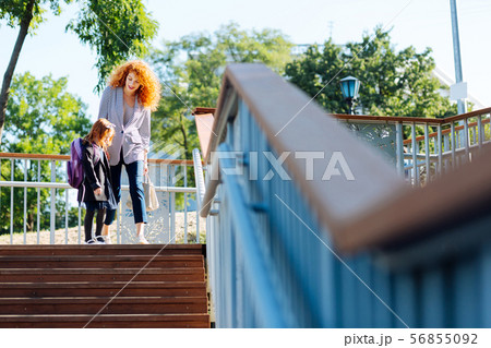 Cheerful red haired female talking to her kid 56855092