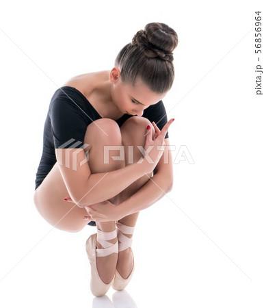 Ballerina on pointes, clutching her knees to chest Ballerina on pointes, clutching her knees to chest 56856964