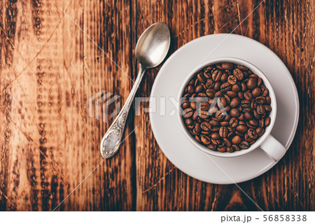 Cup full of roasted coffee beans Cup full of roasted coffee beans 56858338