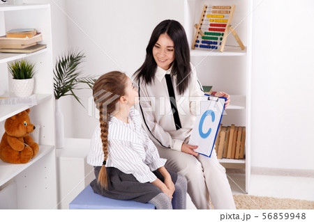 Woman with kid girl training speech together sitting in the white room. 56859948