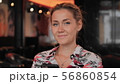 young female Frenchwoman looks at the camera happily and flirtatiously and smiles. Sits in a 56860854