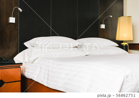 Beautiful luxury comfortable white pillow and blanket on bed with light lamp 56862751