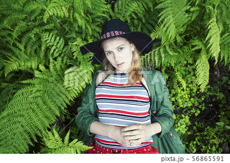 Pretty young blond girl hipster in hat among fern, vacation in green forest, lifestyle people 56865591