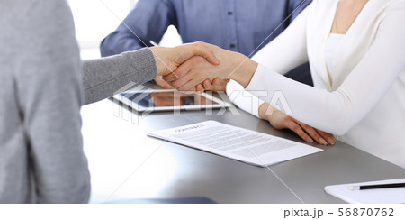 Group of business people shaking hands after discussing questions at meeting in modern office Group of business people shaking hands after discussing questions at meeting in modern office 56870762