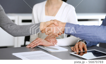 Group of business people shaking hands after discussing questions at meeting in modern office 56870769