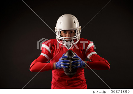 Photo of american female football player in helmet with rugby ball in hands 56871399