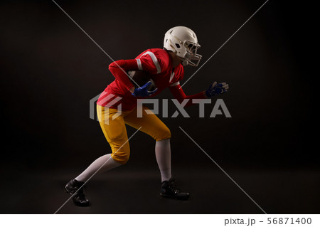 Full-lenght photo of running woman in white helmet with rugby ball in her hand in studio Full-lenght photo of running woman in white helmet with rugby ball in her hand in studio 56871400